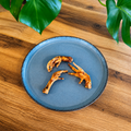 Patte de poulet séchée naturelle de 8 cm pour chien sur assiette bleu